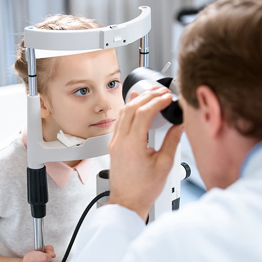 A child having an eye examination at a slit lamp with an ophthalmologist