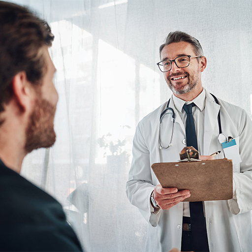 A doctor holding a clipboard talking with a male patient