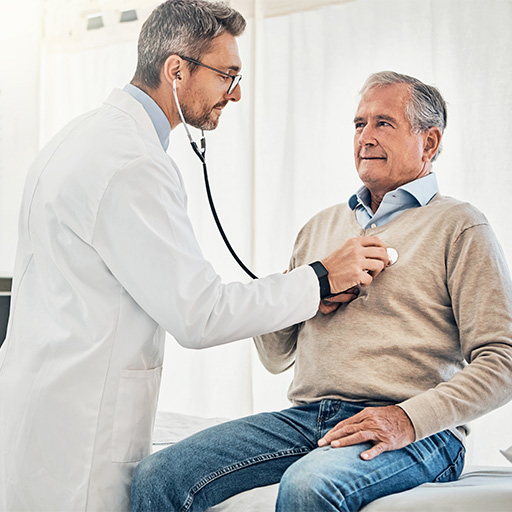 A doctor listening to an older man's chest with a stethoscope