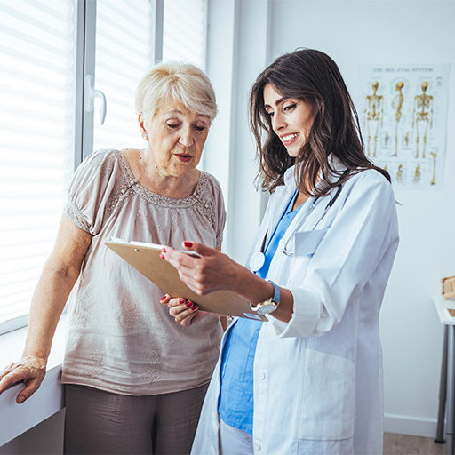 A doctor going through results on a clipboard with an older woman beside a window