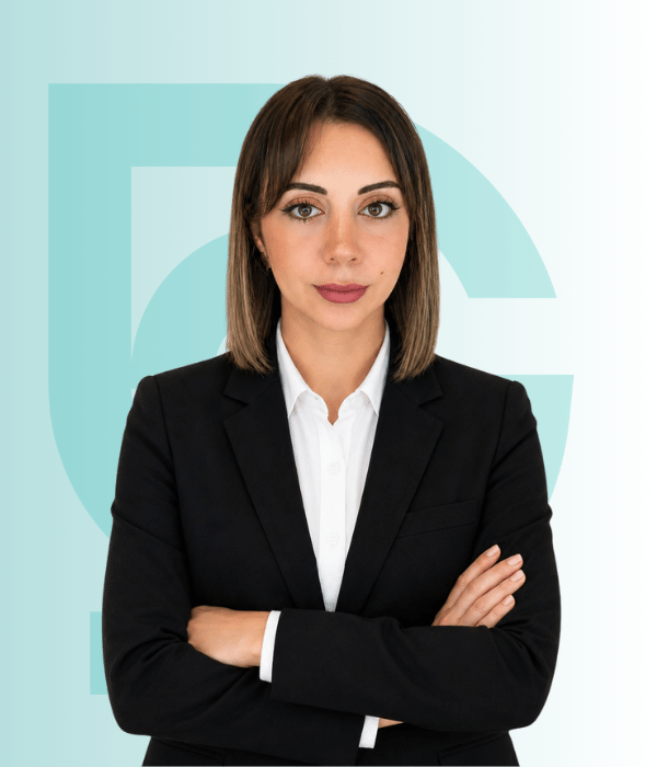 Professional woman in black blazer with crossed arms at Acibadem Hospital.