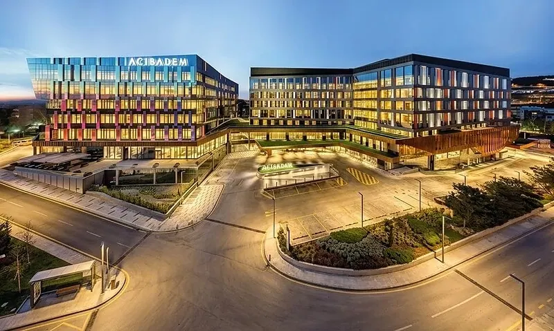 Modern exterior view of Acibadem Altunizade Hospital at dusk.