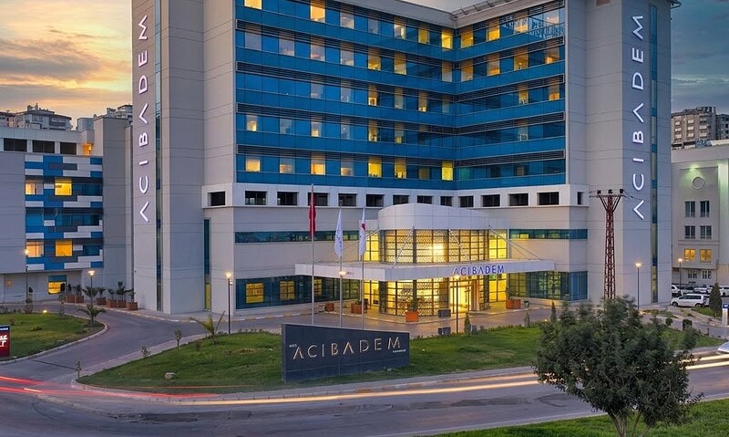 Modern hospital building with blue and yellow accents at sunset.