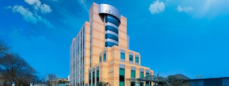 Modern Acibadem Kozyatagi Hospital building with blue sky background.