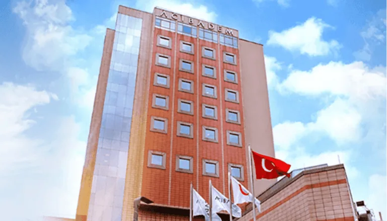 Acibadem Hospitals Group building with Turkish flags, modern healthcare facility in Turkey.