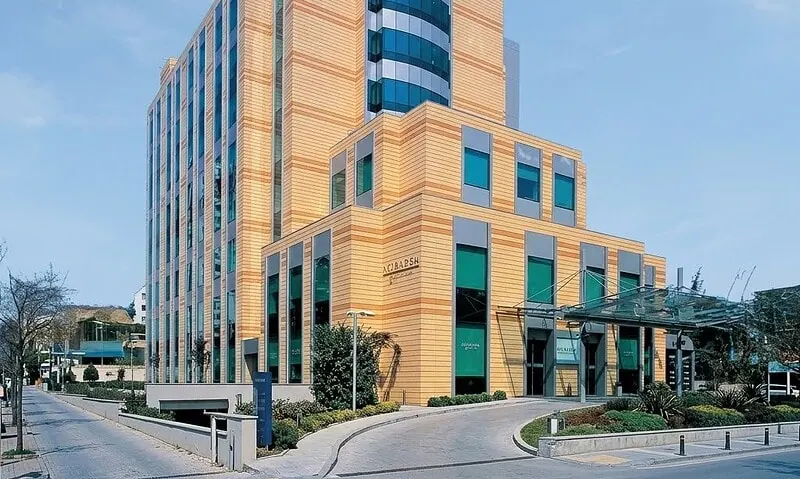 Modern hospital building with glass facade and orange exterior in Istanbul.