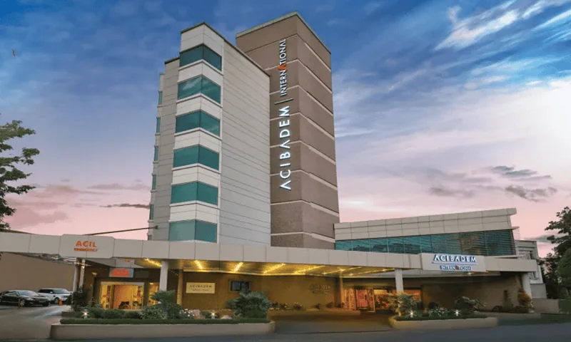 Acibadem Hospitals Group building exterior at sunset, showcasing modern healthcare facility and hosp.