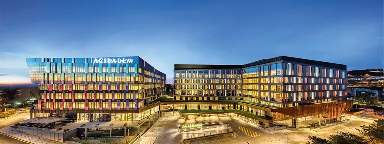 Modern exterior view of Acibadem Altunizade Hospital at dusk.