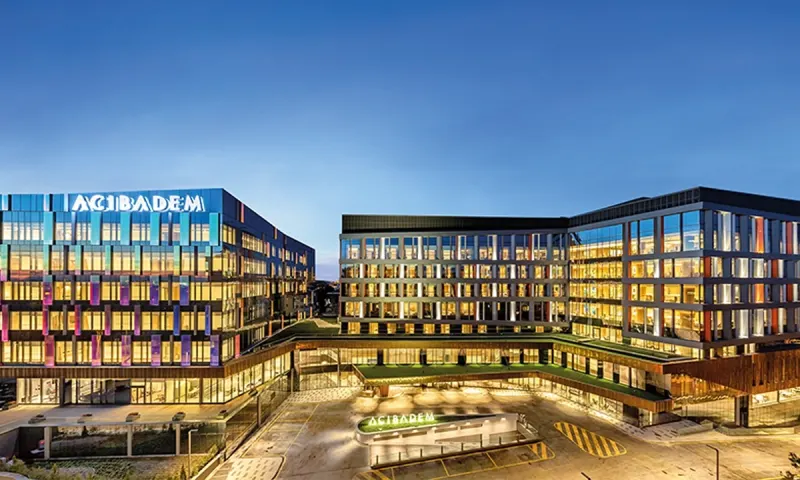 Modern exterior view of Acibadem Altunizade Hospital at dusk.