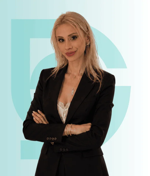 Professional woman in black blazer with crossed arms at Acibadem Hospitals Group.