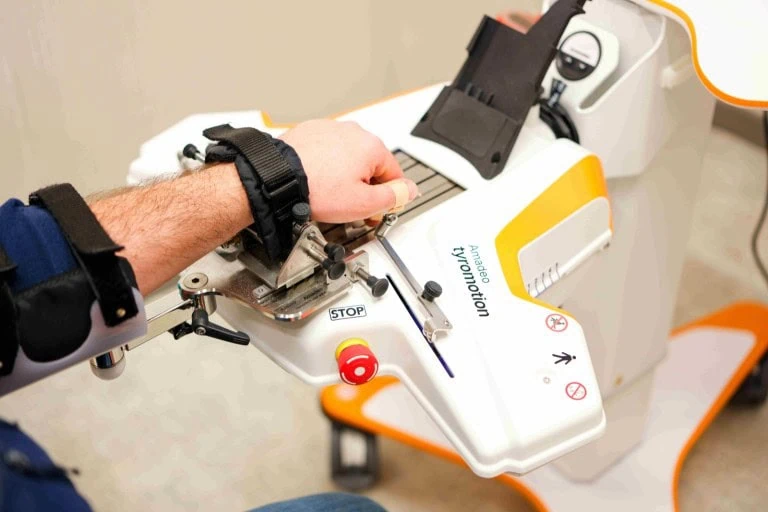 A patient hand and forearm strapped into the Amadeo robotic finger rehabilitation device