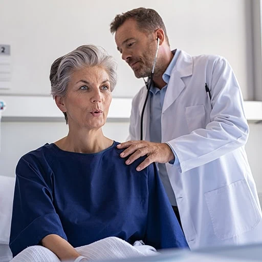 A doctor listening to a patient's chest with a stethoscope, heart and lung health screening at Acibadem