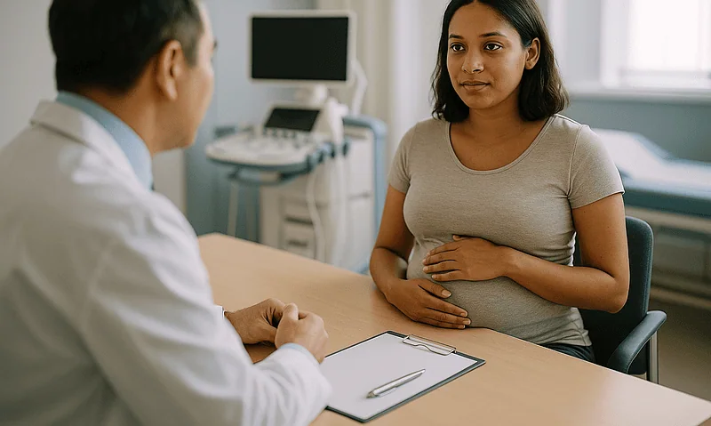 Pregnant woman consulting with doctor in a medical office.
